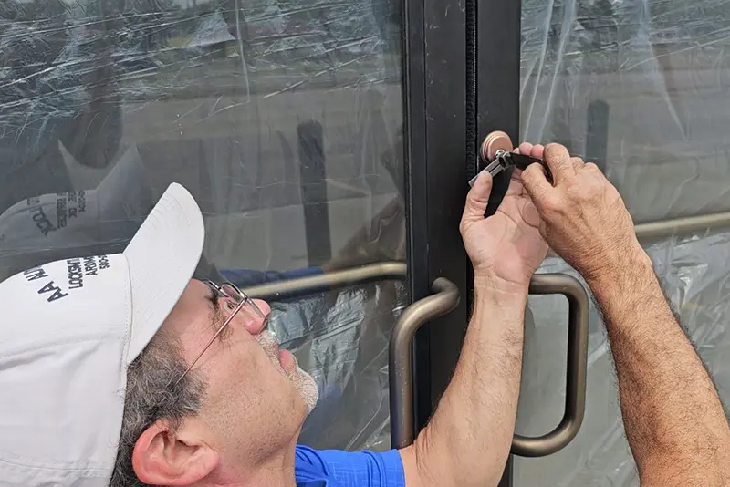 Locksmith repairing a electronic lock at a business