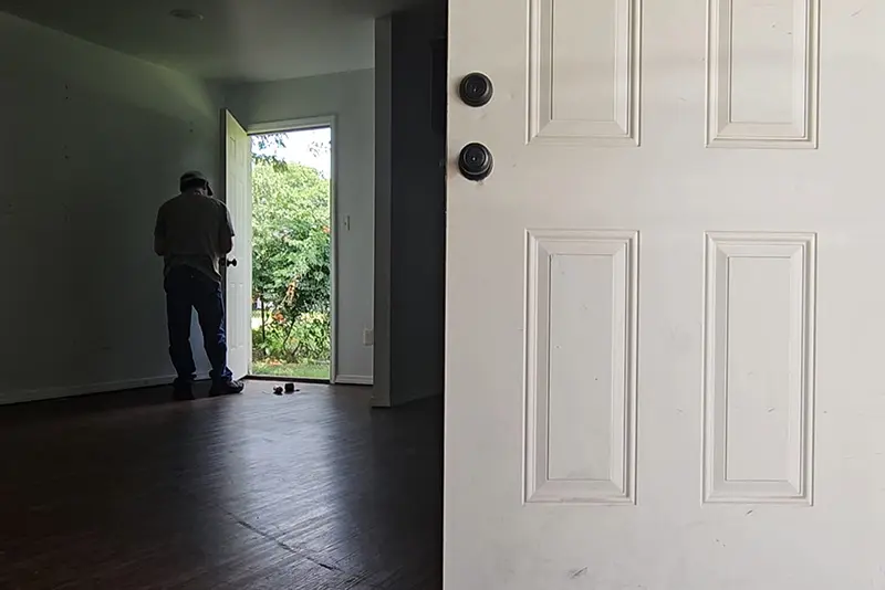 Locksmith installing a new lock cylinder on a homes door