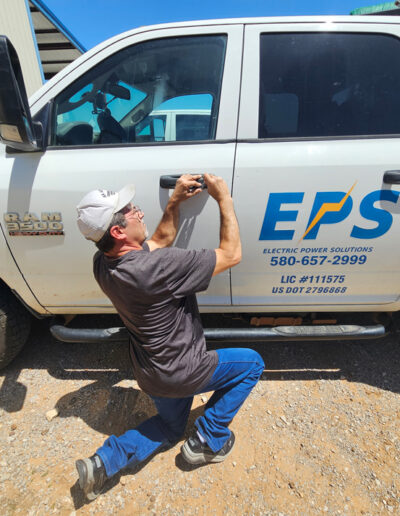 Man kneeling while extracting key piece stuck in car lock.